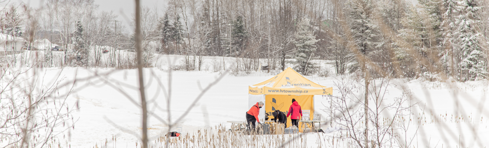 A Laurentian Valley pop up tent out in the middle of winter on a lake.
