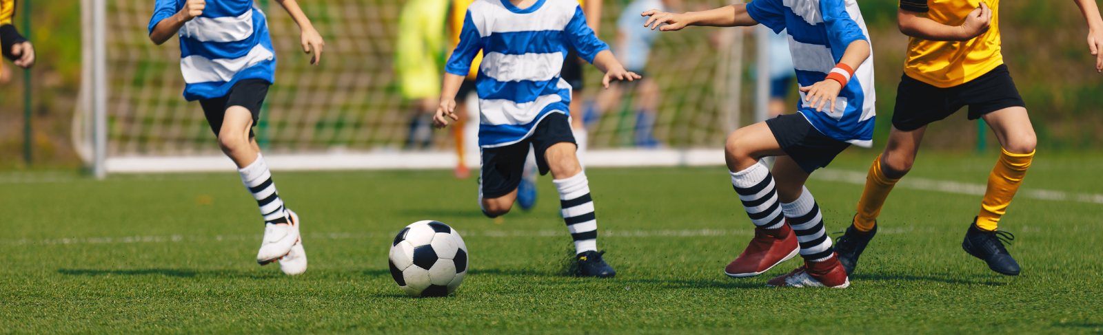 Soccer players dribbling a ball.