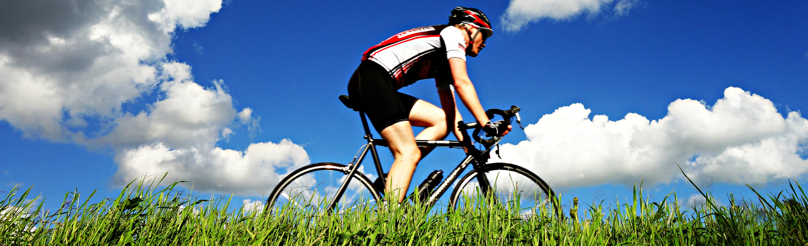 A cyclist on a clear blue sky day.