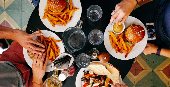 An aerial photo of people eating burgers. 