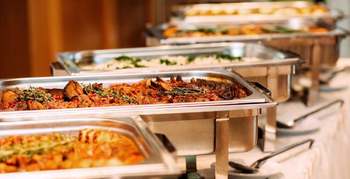 A group of chaffing dishes full of food. 