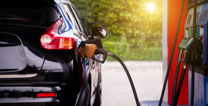 A car at a gas station pumping gas.