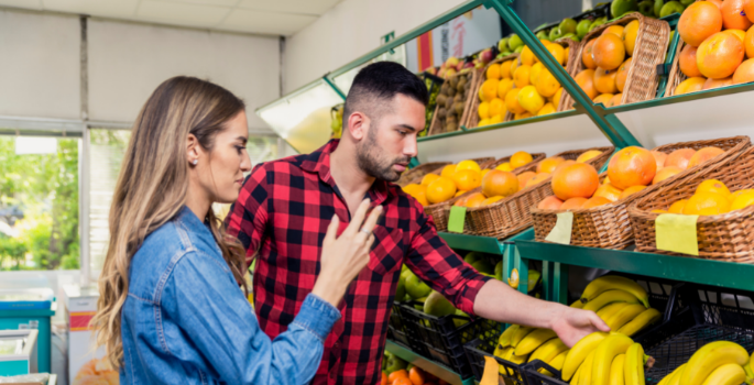 Two people grocery shopping.