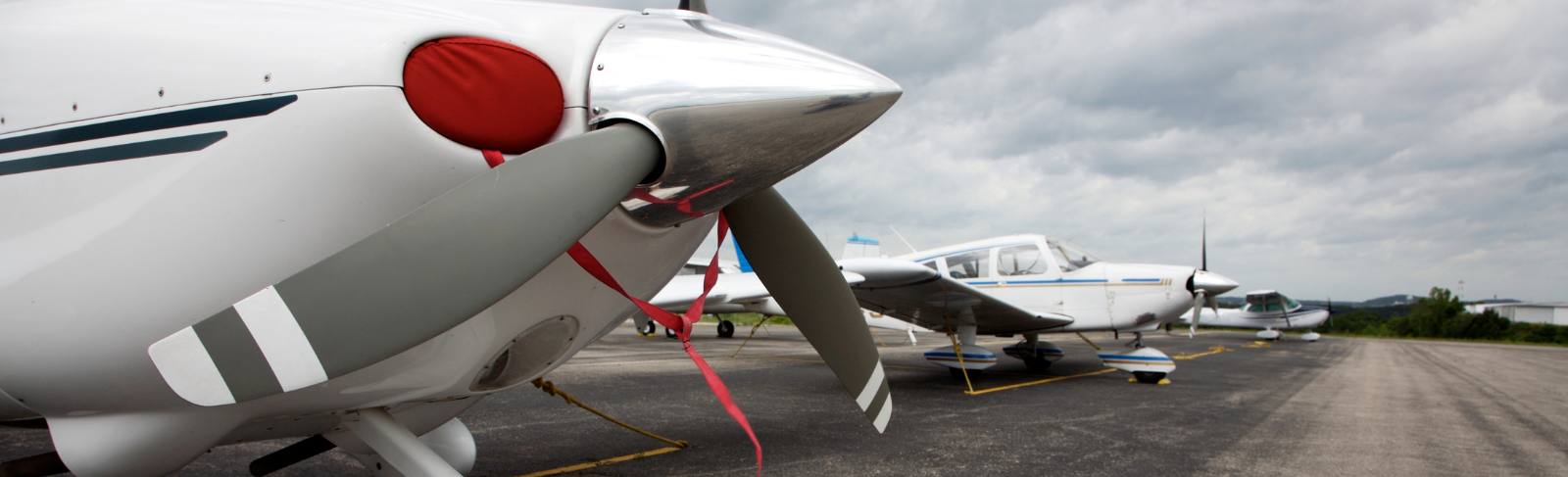 Small propeller planes lined up at an airport.