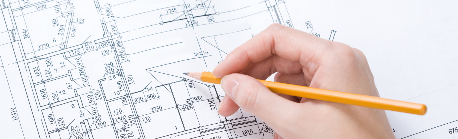 Hand holding a pencil writing on a draft paper.