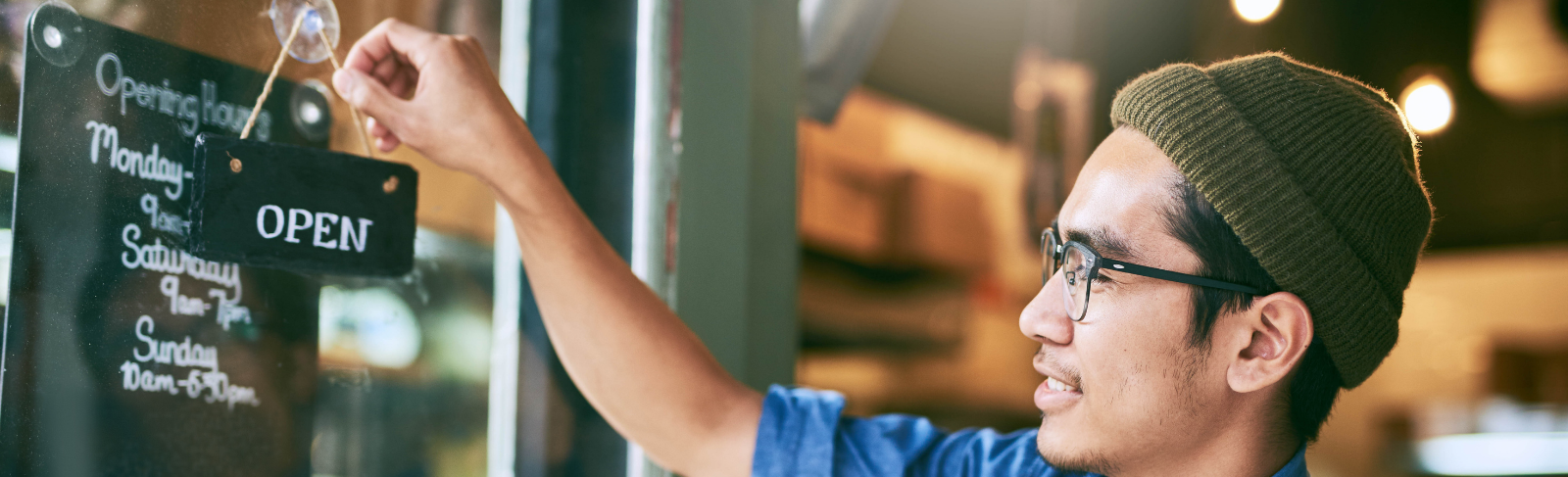Person turning a business sign to open.