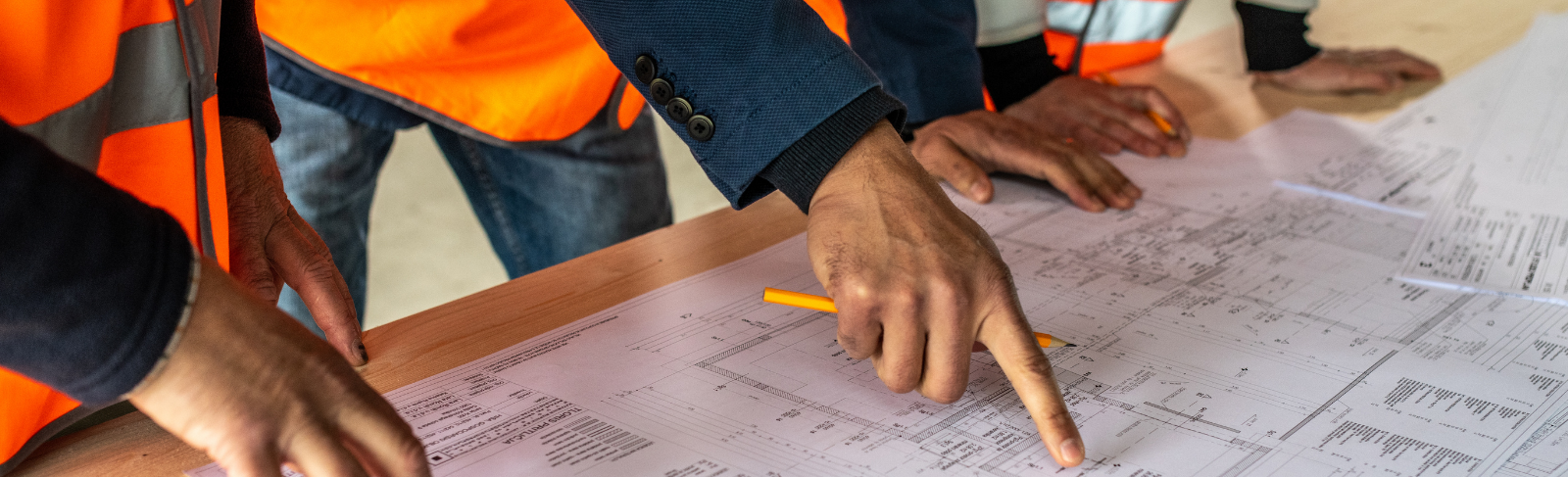 Labourers looking at a site plan together. 