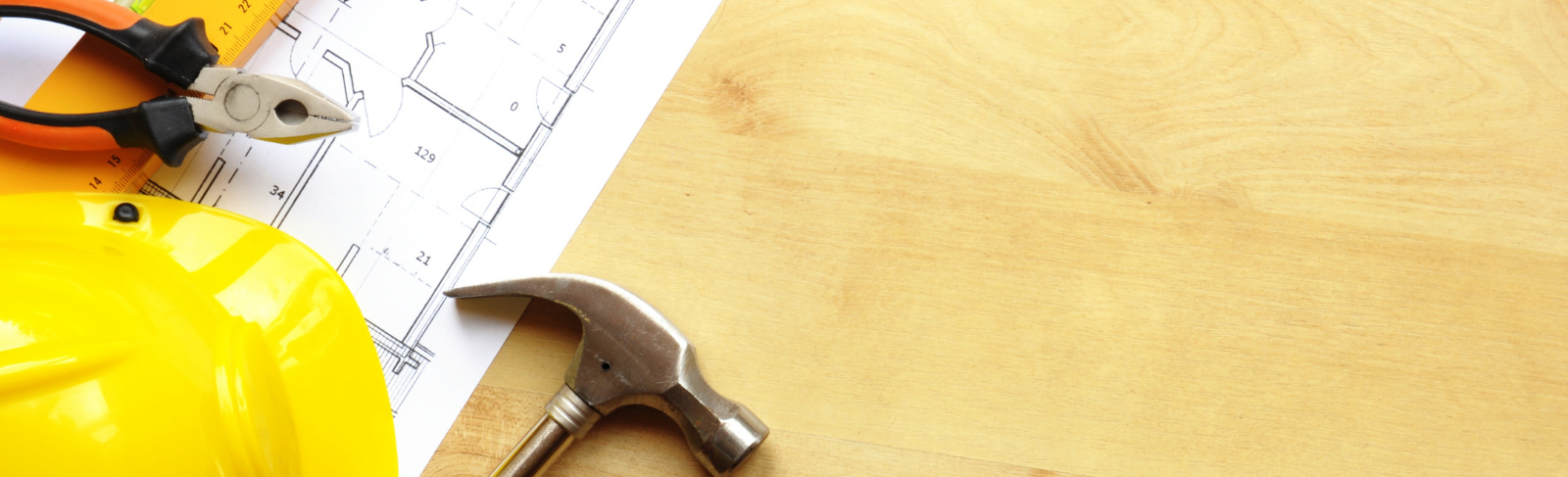 Flat lay of draft paper, hard hat, and a hammer.