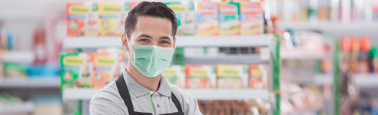 A grocery store worker wearing a mask.