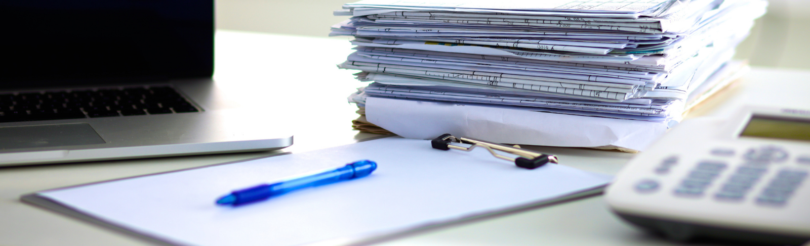 Stack of folders behind a clipboard.