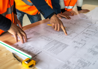 Labourers looking at a site plan together. 