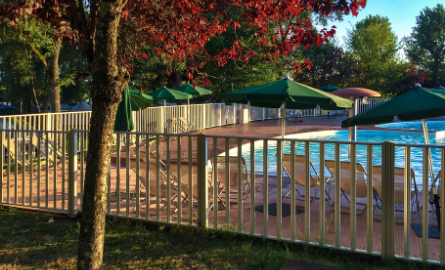 A fenced in outdoor in ground swimming pool.