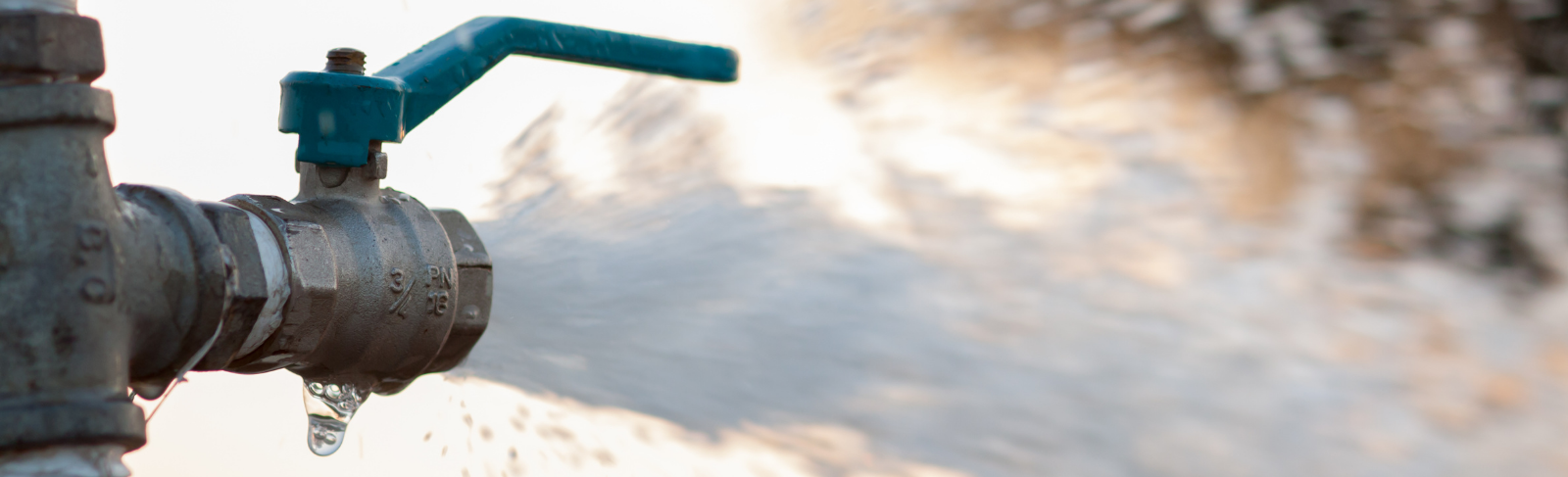 An open water main with water gushing out.