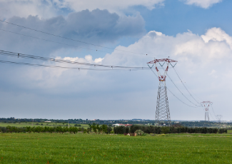 Power lines in the background of an open lands and fields.