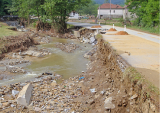 An eroded roadway due to flooding and washout.