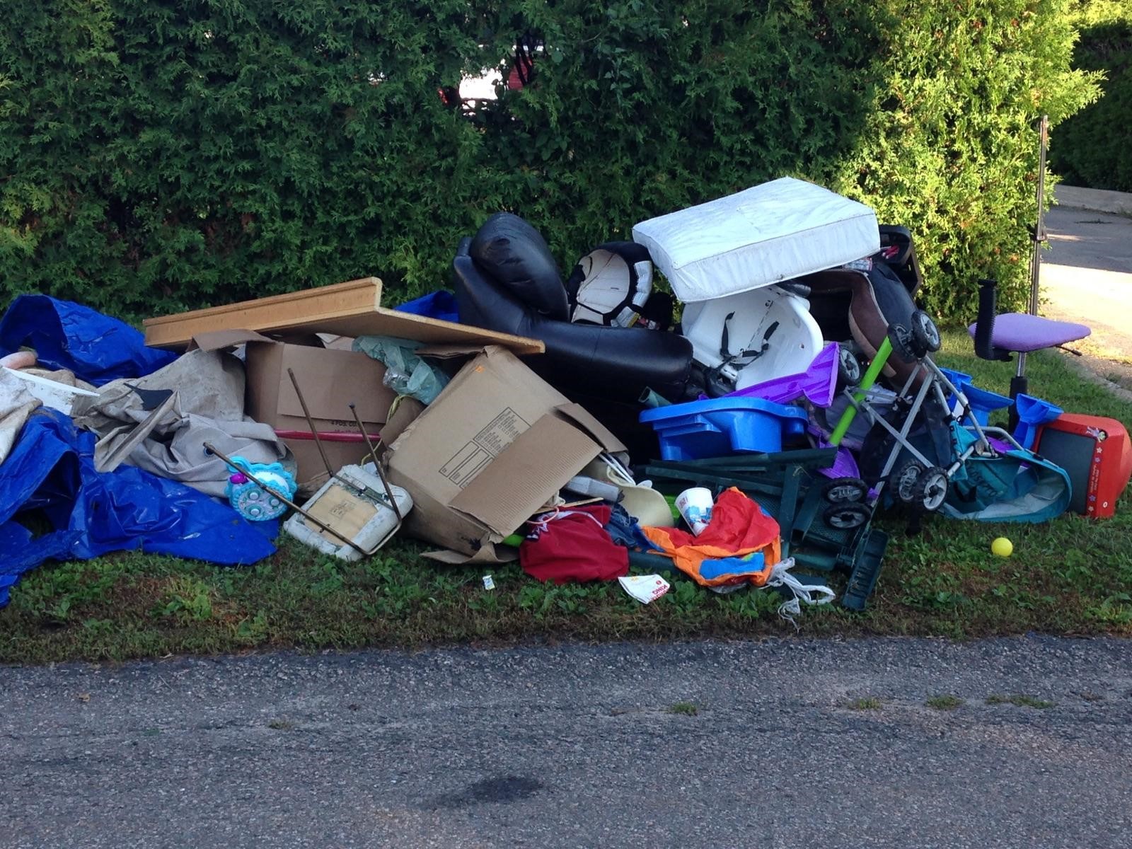 A pile of large items loosely thrown together at the end of the driveway displaying how to incorrectly place items for collection.