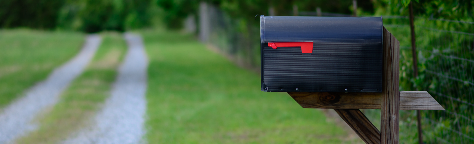 A rural mailbox on a country road with the flag up.