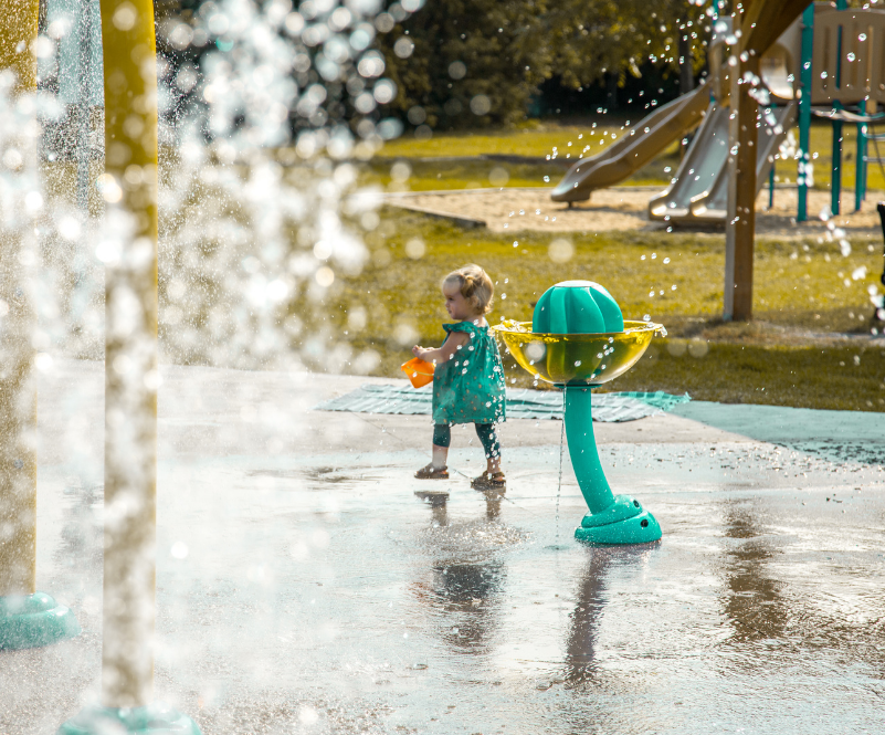 Little girl playing in the water at the splash pad.